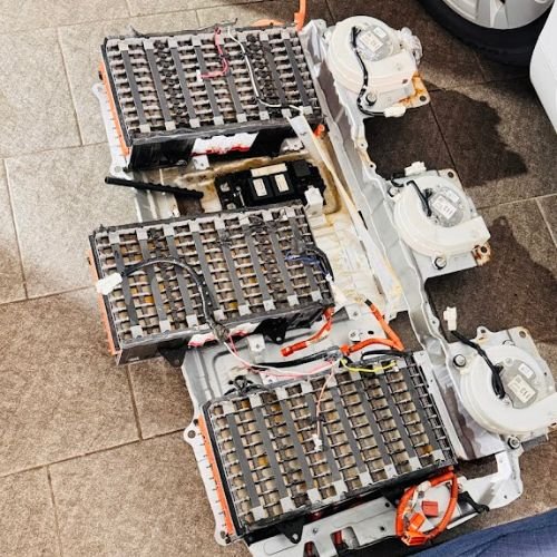 Three dismantled hybrid battery packs with exposed cells, wiring and cooling fans.