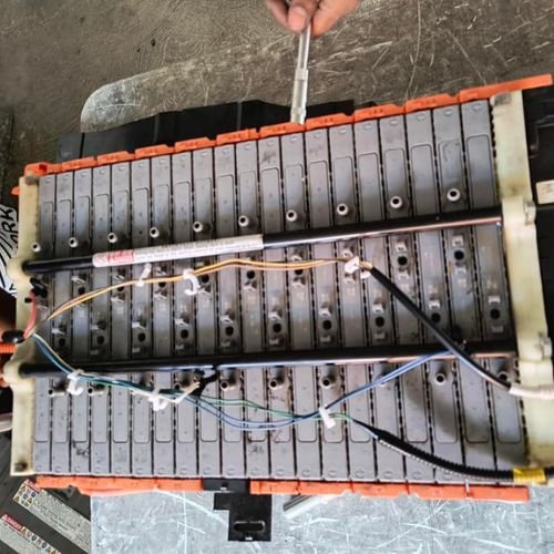 Open hybrid battery pack with exposed modules and wiring being worked on.