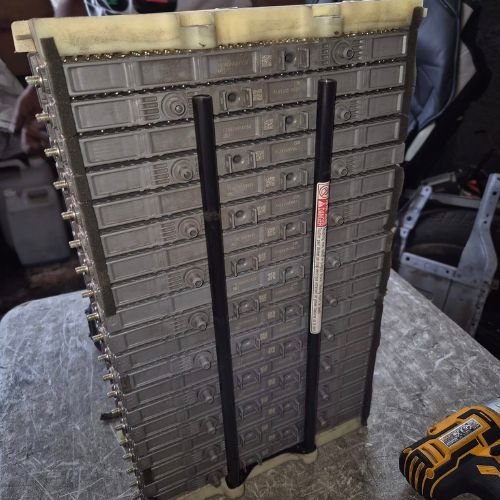 Hybrid battery module assembly standing upright on a workshop bench.