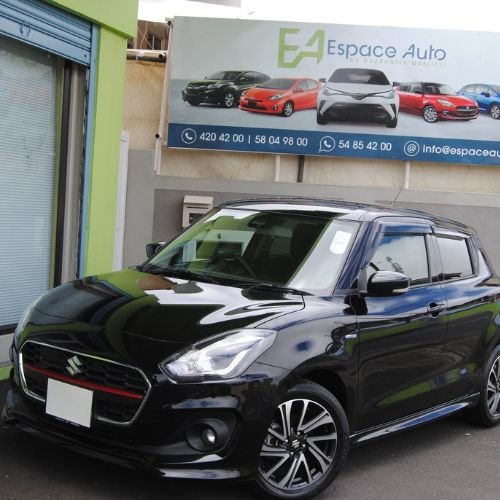 Black Suzuki Swift at car dealership parking