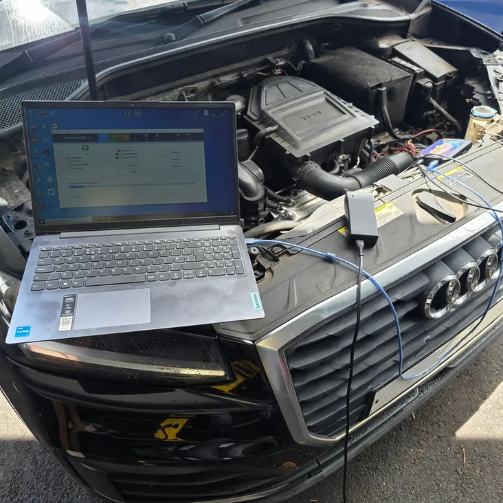 Laptop connected to an Audi for vehicle diagnostics.