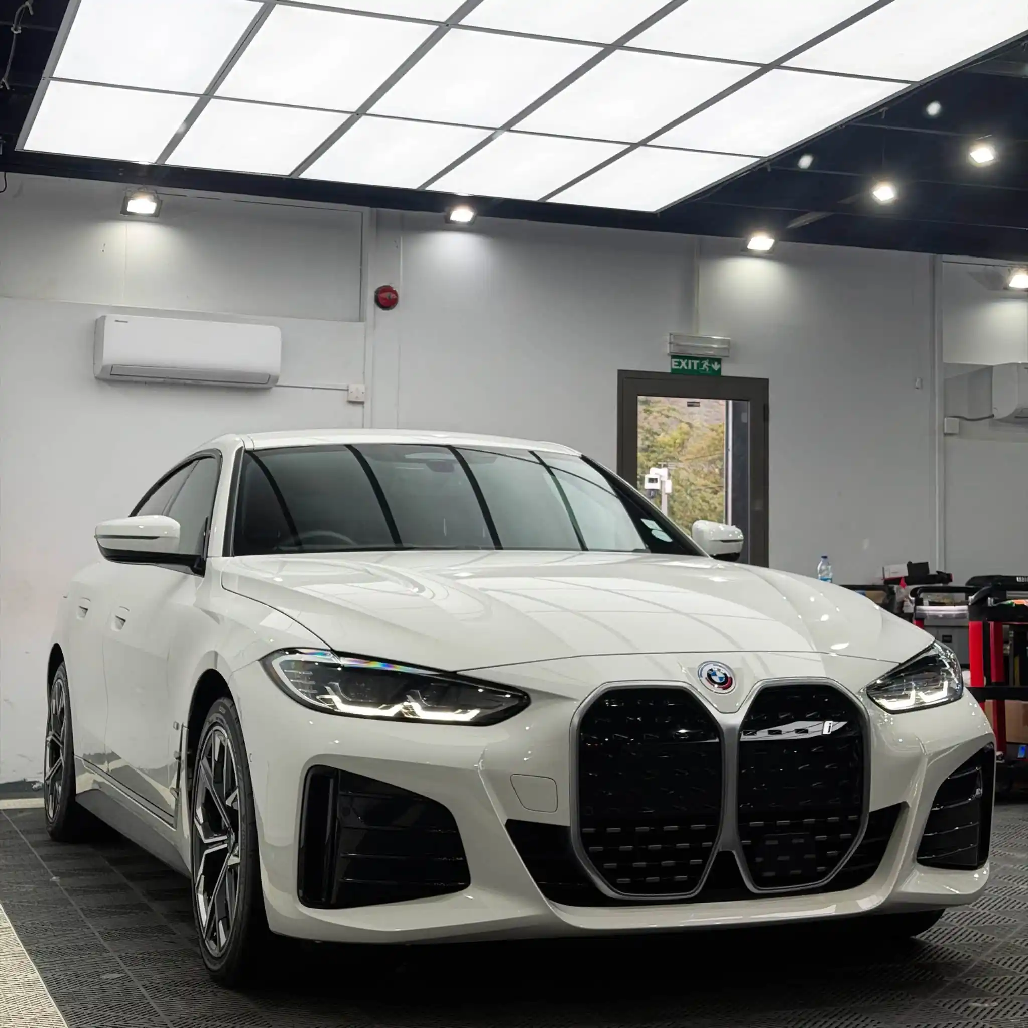 White BMW 3 Series in a detailing workshop