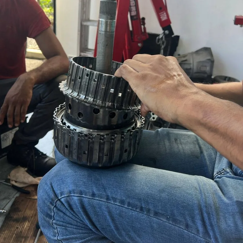 Mechanic working on an automatic transmission assembly.