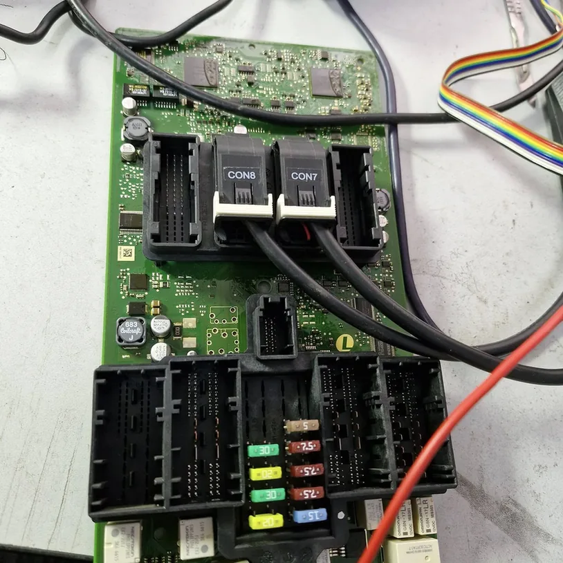 BMW body control module circuit board undergoing electronic repairs.