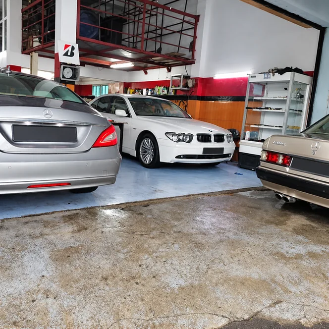 BMW and Mercedes-Benz cars parked inside the workshop.