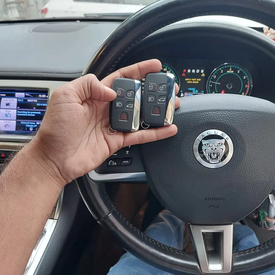 Two Jaguar key fobs held inside a Jaguar during key programming.