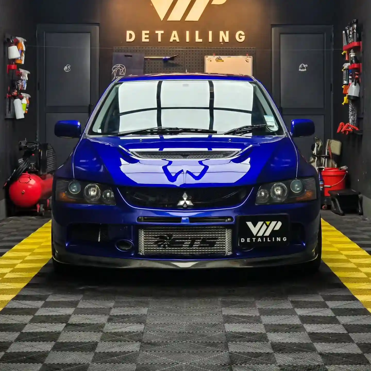 Blue Mitsubishi Lancer Evolution in a car detailing workshop